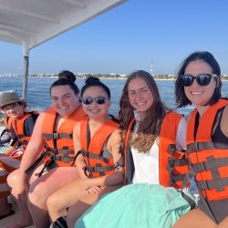 Students and their instructor ride a boat out to the reef wearing lifejackets and big smiles on a study abroad adventure in Yucatan.