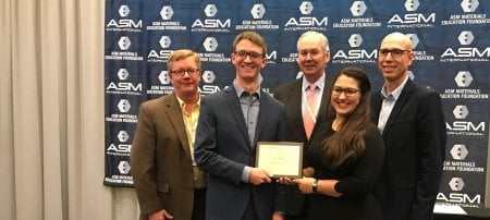 Celebrating the beginning of a winning streak: the 2019 student design team. From left, advisor Dr. Walt Milligan; student Kyle Hrubecky; William Mahoney, Chief Executive Officer of ASM International; student Erin VanDusen; and advisor Paul Sanders. Not pictured: students Lucas Itchue and Jacob Thompson. (Image courtesy ASM and Michigan Tech MSE)