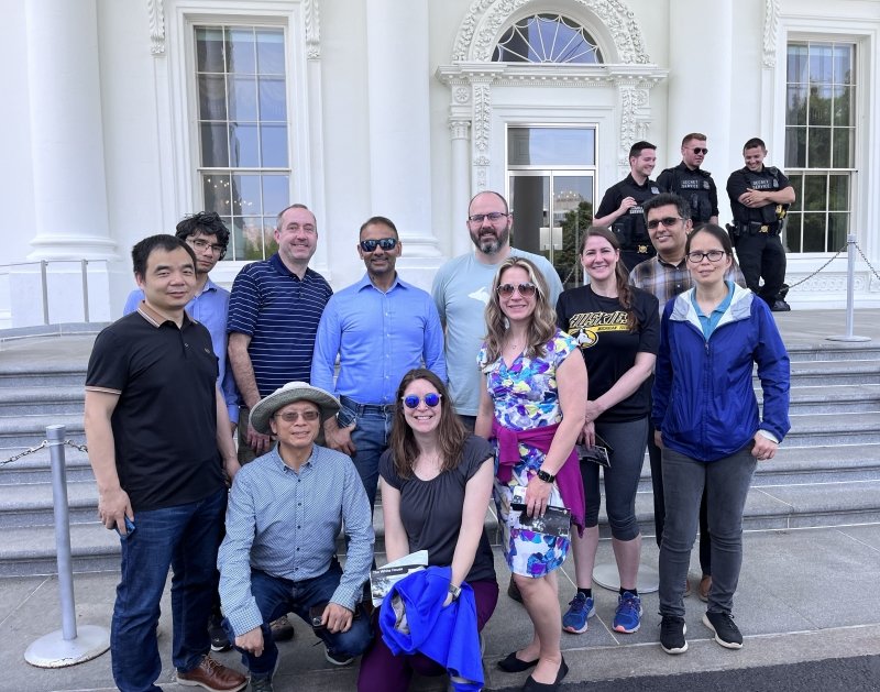 Researchers take a last photo on the White House portico after their tour as security looks on.