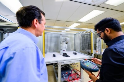Nathir Rawashdeh watches a student work a programmable controller in the mechatronics playground.