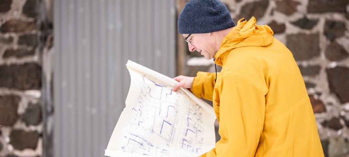 Tim Scarlett examines an old map at the Quincy Mine in Hancock, Michigan. A stack of fragile mine maps sparked a collaboration between archaeologists and computing researchers — turning forgotten underground tunnels into digital models for the future.