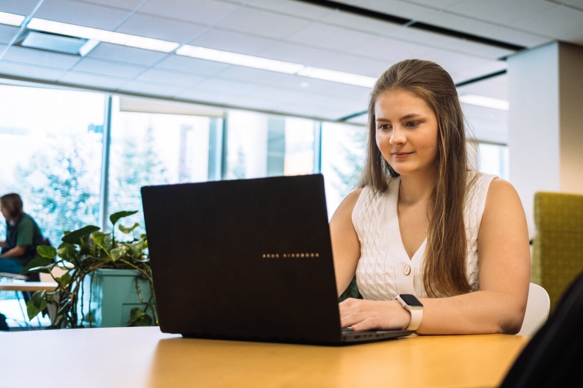 Felicia Huffman sits in Michigan Tech's library working on her laptop.