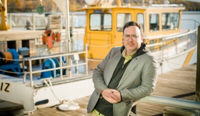Tim Havens poses on the dock of the Great Lakes Research Center, in front of the RV Agassiz.