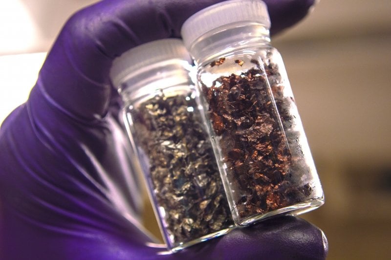 purple gloved hands hold vials of copper and lithium