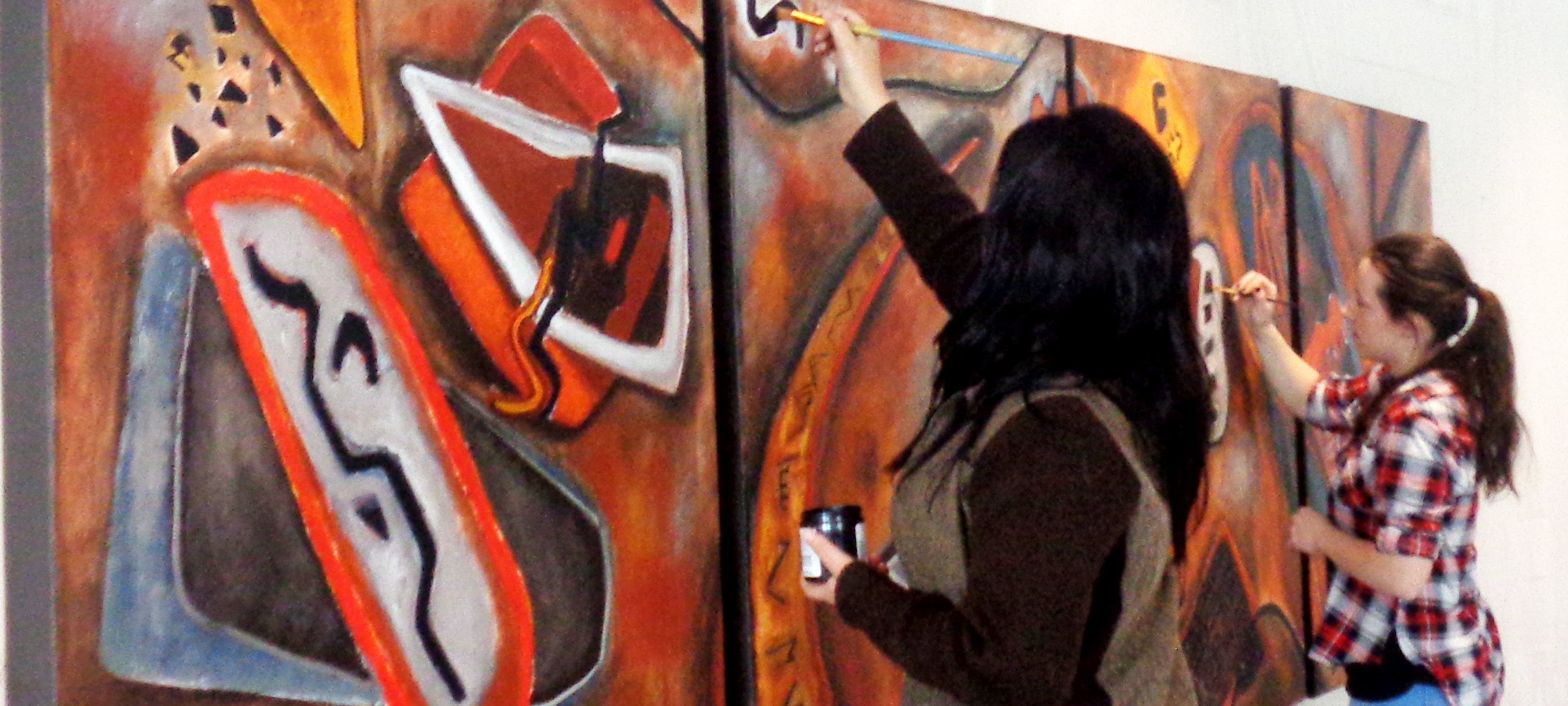 Visiting artist Raquel Alvizures paints a mural for the Rozsa Center with student Kassie Baril .