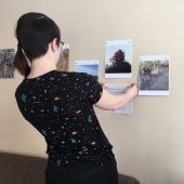 Mads Howard and Kihn Hughes arranging the exhibit Art and Nature mindful cell phone photos at Omega House, where people seek hospice services.