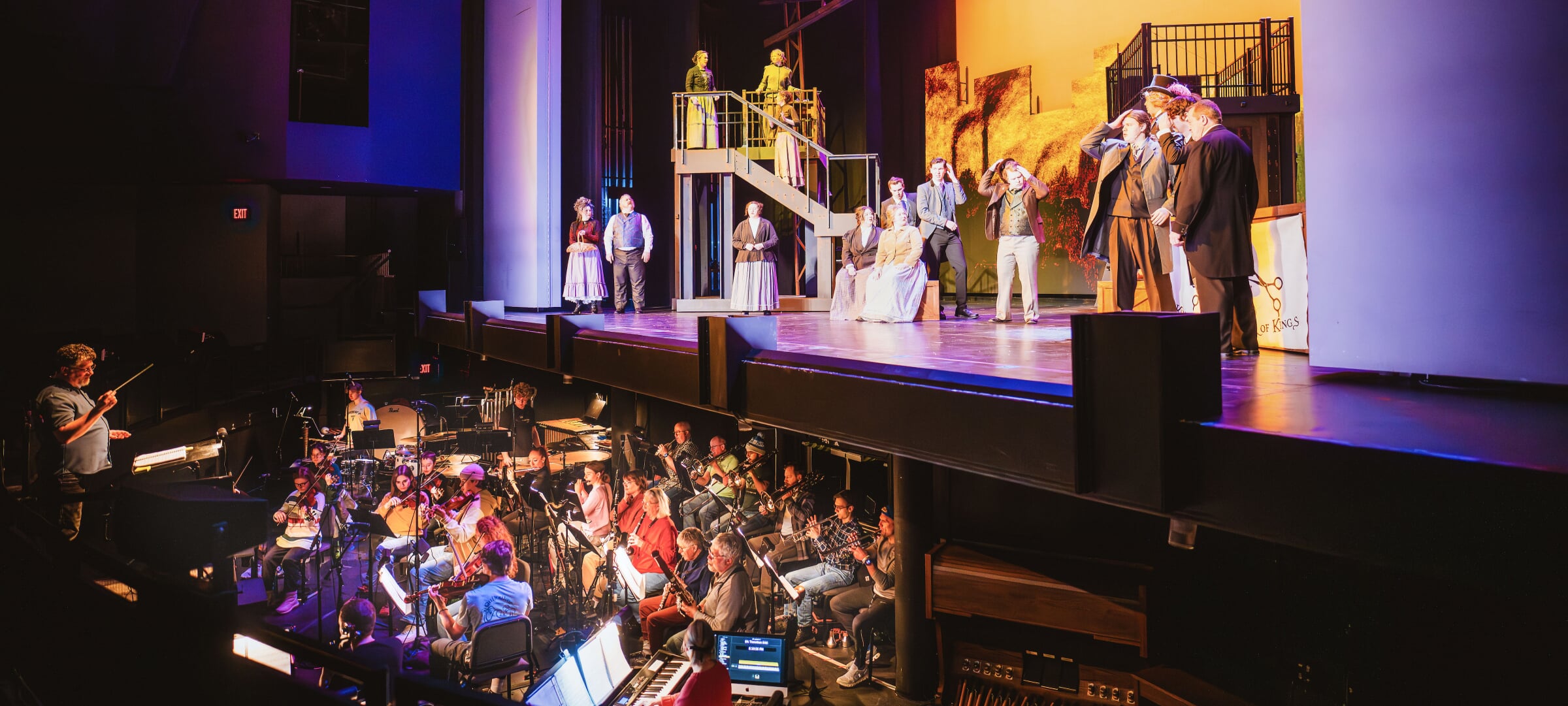 Orchestra performs below and in front of stage performers