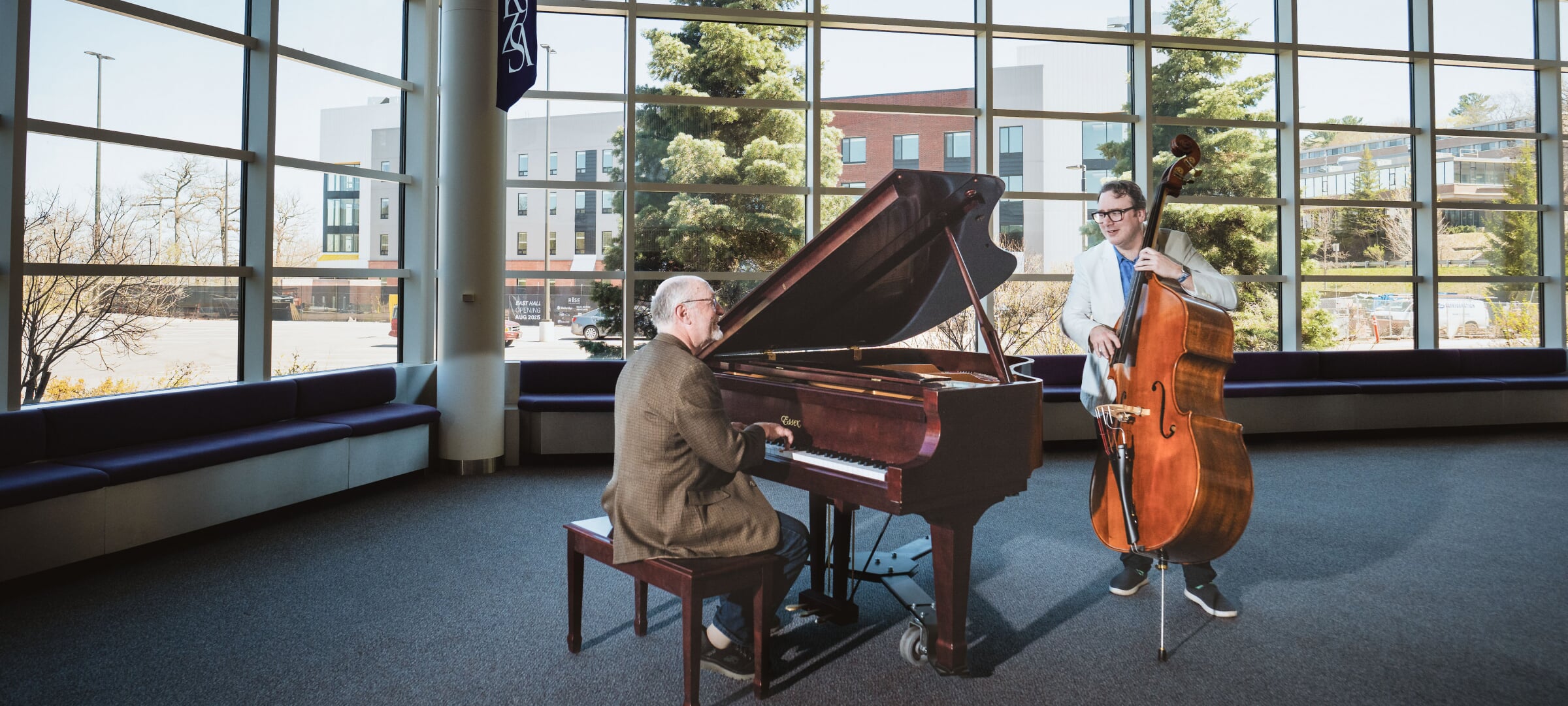 Faculty perform a piano/bass duet in the lobby of Rosza Center for the Performing Arts