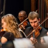 Students playing in the Keweenaw Symphony Orchestra, a close view of the violinists.