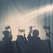 Four children perform a play with puppets