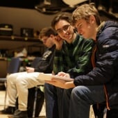 Performance Club students sitting while reviewing a script.