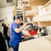 Student using a skill saw in the scene shop.