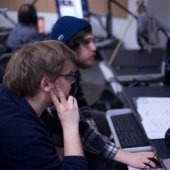 Two students sitting inside the CAML Design Lab in front of computers.