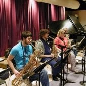 Students sitting playing instruments in the Instrumental Rehearsal room.