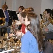 Students sitting with their instruments behind music stands with music in the Instrumental Rehearsal Room