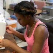 Student using a sewing machine to sew a piece of costuming.