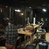 Two students working inside of a room overlooking the stage.