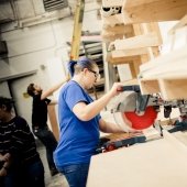 Student working on a wooden project using a skill saw.